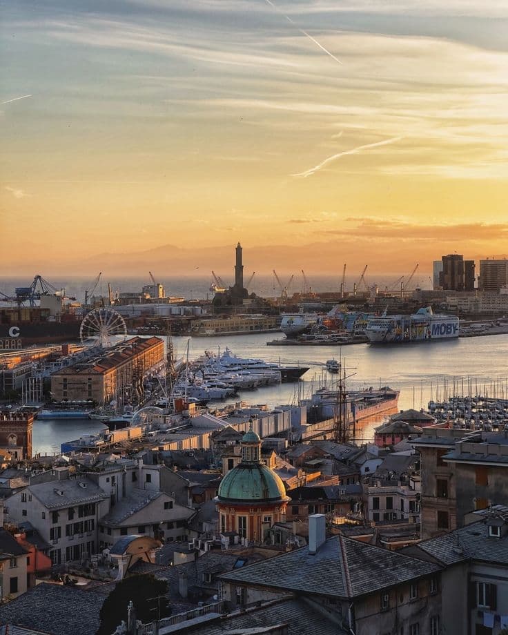 Il porto di Genova al tramonto, con la Lanterna e i tetti della città vecchia.